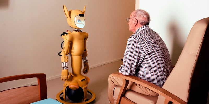 Elderly man converses with a yellow robot.